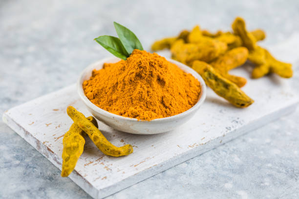 istock Indian turmeric powder and root. Turmeric spice. 1357243625