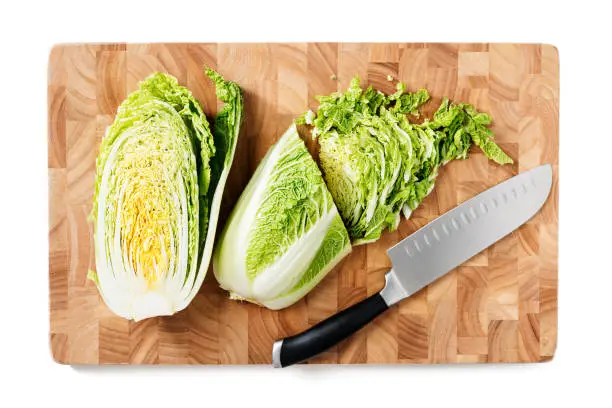 Cutting Board with fresh cut chinese cabbage. isolated on white background. top view