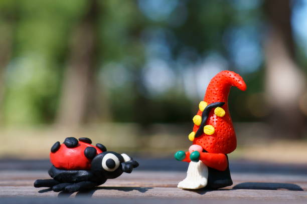 istock A figure of a dwarf and a ladybug on a colored background. 1357250258