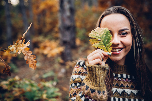 a woman with an autumn leaf