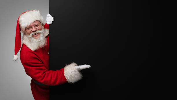 istock Santa Claus pointing at banner 1357255175