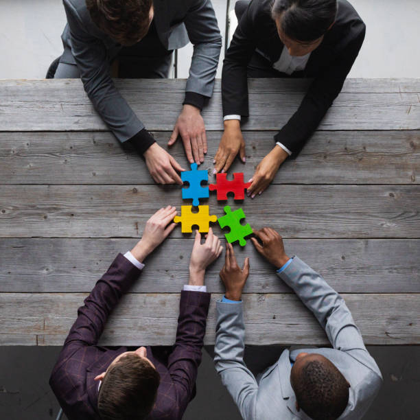 Business people assembling puzzle, stock photo