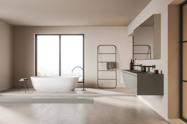istock Light bathroom interior with bathtub near window, sink and ladder 1357260133