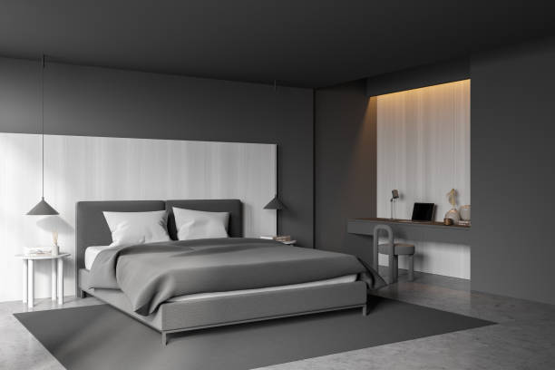 istock Grey bedroom interior with bed on concrete floor, workplace with computer 1357262389