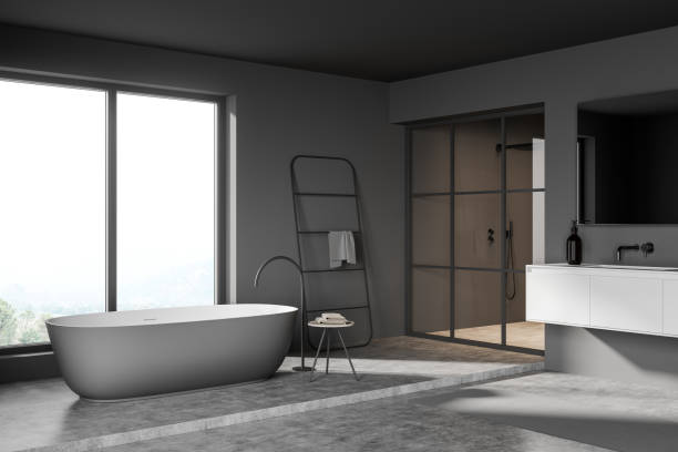 istock Dark bathroom interior with bathtub and window, sink and shower 1357262409