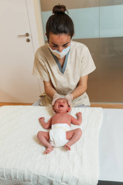 Professional physiotherapist doing a positional plagiocephaly correction on a newborn baby. Professional physiotherapist doing a positional plagiocephaly correction on a newborn baby. Health and medical concept. plagiocephaly stock pictures, royalty-free photos & images