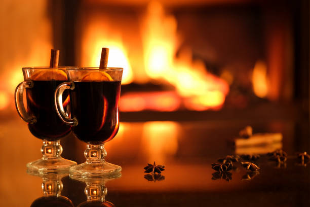 istock Two glasses with mulled wine on the fireplace background. 1357263537