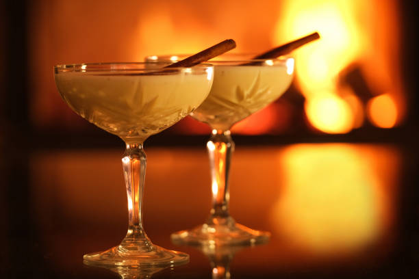 istock Two glasses with eggnog and cinnamon on the fireplace background. 1357263556