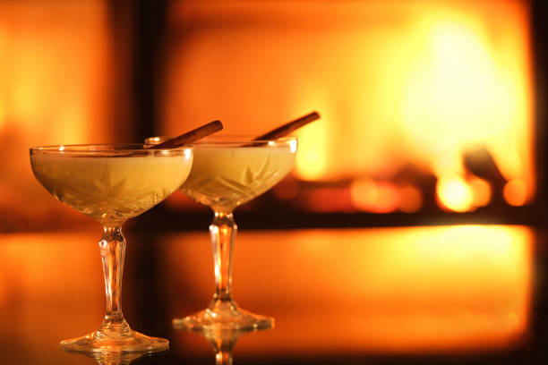 istock Two glasses with eggnog and cinnamon on the fireplace background. 1357263565