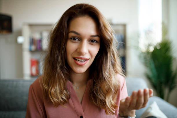 Headshot of young smiling woman having video call at home stock photo