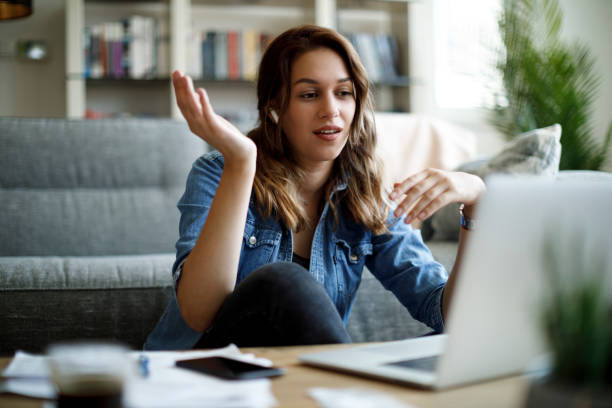istock Young woman makes a video call on her laptop computer at her home office 1357265495