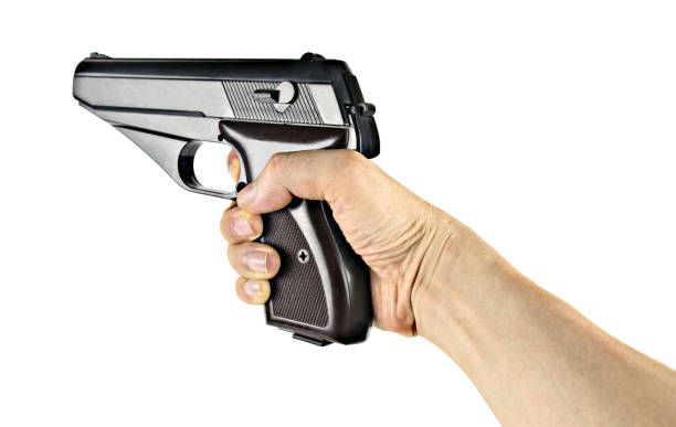 istock Man hand holding a black gun isolated on white background 1357266681