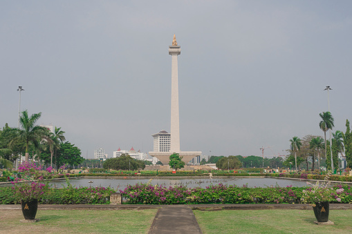 Symmetrical view of Indonesia National Monument and the garden park area in Indonesia
