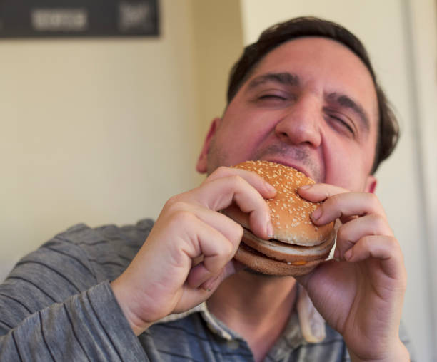 istock Hungry man biting fresh tasty hamburger 1357267728