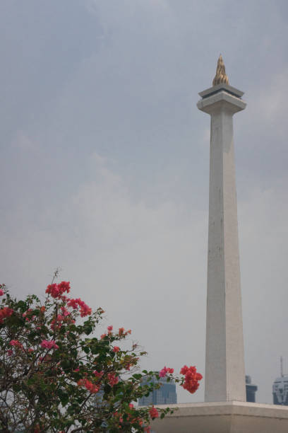 istock Indonesian National Monument Monas with red flower blossom 1357268651
