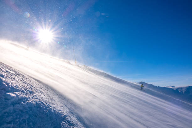 Lone Skier on a Sunny Slope and Blizzard