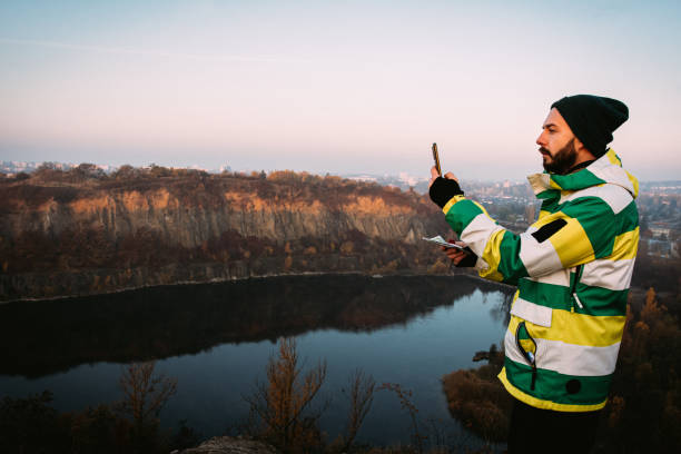 mid adult man with mobile phone in hands outdoors. - thirty pieces of silver imagens e fotografias de stock