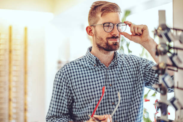 istock Young man buying eyelasses at the optical store 1357271056