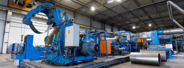 istock Panoramic photo. Metal sheet profile forming machine, process of making steel tile for roof, industrial manufacturing. Background of plant and factory 1357272219