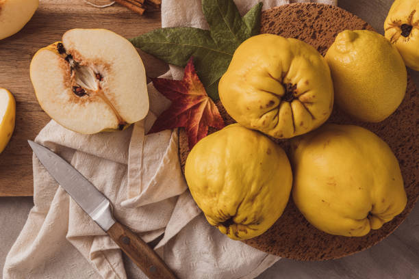 Ripe whole and sliced quinces. Fresh fruit for preparing recipes with cinnamon and lemon. An essential ingredient for a healthy diet