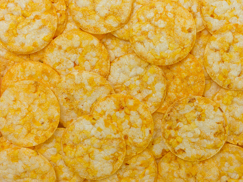 many round rice chips with cheese flavor - food background