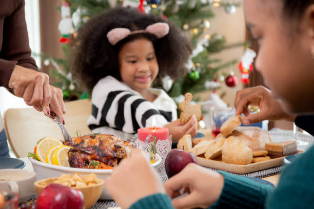 les mains rapprochées de la mère utilisant un couteau tranchant de la viande de dinde rôtie sur des plats à manger à la maison le jour de la veille de thanksgiving, célébration de noël avec repas en famille, nouvel an, fête et vacances. - new years day new years eve new year ethnic photos et images de collection