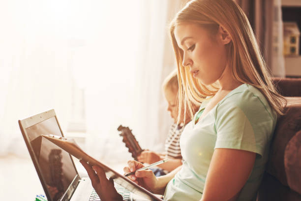 istock Young woman with child studying on laptop, making notes 1357275749