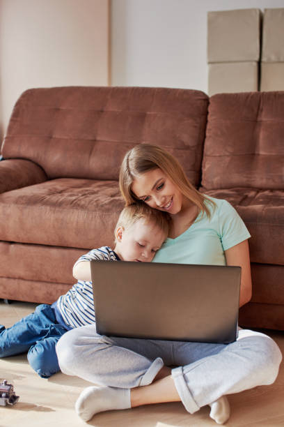 istock Young woman with child working on laptop 1357275760