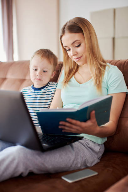 istock Lonely mother entertaining her son while staying at home 1357276979