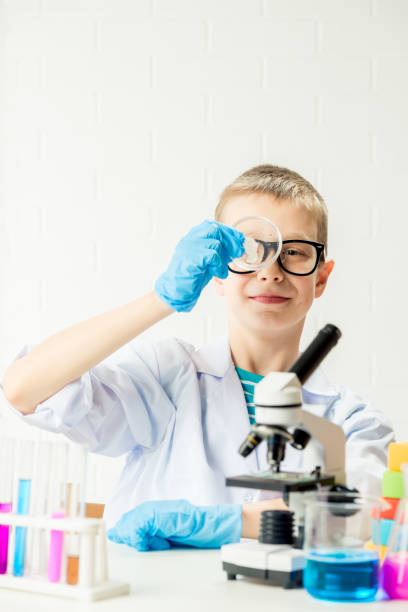 istock A schoolboy with a microscope examines chemicals in test tubes, conducts experiments - a portrait on a white background. Concept for the study of coronavirus in the laboratory 1357278969