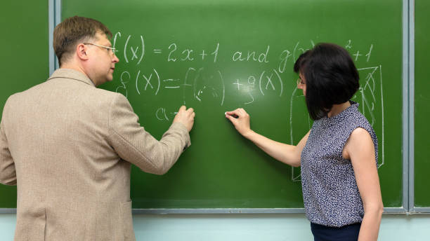 istock An adult teacher at the blackboard explains the solution of a math problem to his student