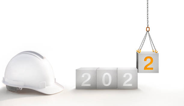 o ano de 2022 em concreto e aumentar números 2 novas laranjas por um guindaste de construção em fundo branco - year block cube new years eve - fotografias e filmes do acervo