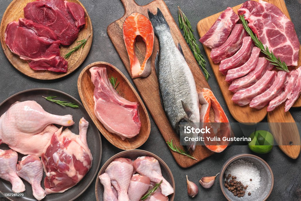 Assortment of raw fresh meat on dark grunge background. Beef, pork, fish, chicken and duck. Top view, flat lay. Assortment of raw fresh meat on dark grunge background. Beef, pork, fish, chicken and duck. Top view, flat lay Protein Stock Photo