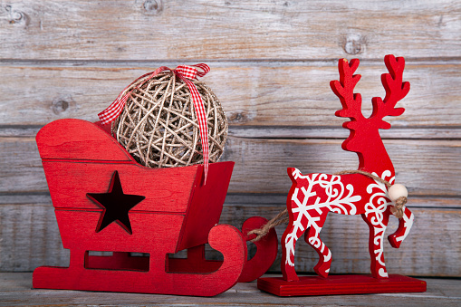Christmas decorative wooden Santa's sleigh on rustic wooden background.