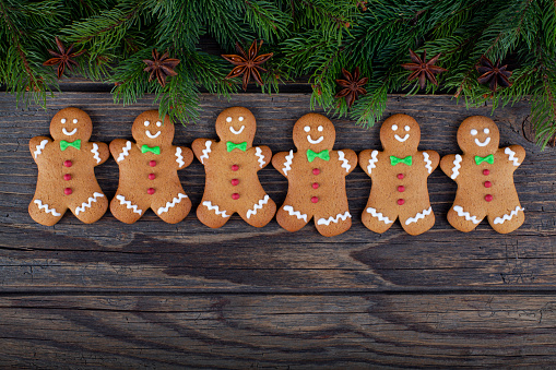 Christmas gingerbread men cookies and fire tree on rustic wood