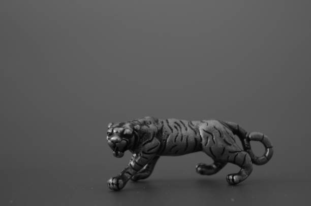 Metal tiger figurine on a dark background.