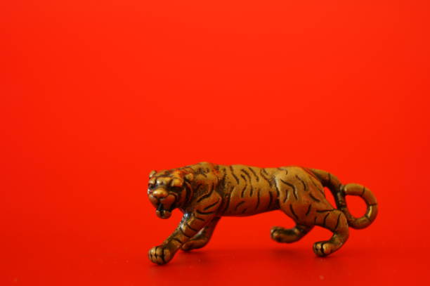 istock Metal tiger figurine on a red background. 1357293827