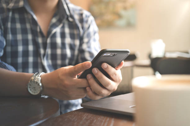 istock Close up hands of man handsome using smart phone in coffee shop cafe. 1357293909