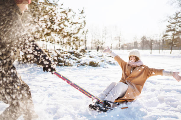 istock Young couple having fun and  rolls on a sled in the winter snowy forest. 1357299965