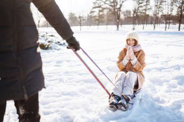istock Young couple having fun and  rolls on a sled in the winter snowy forest. 1357299993