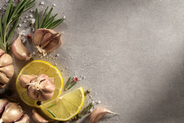 Garlic, rosemary, lemon  on grey background. Spices, herbs, parsley, top view.