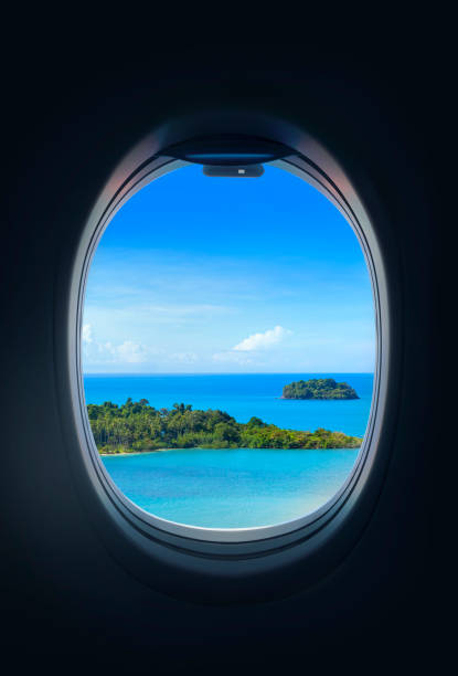 섬에 비행기의 창을 통해 찾고. 여름 여행 목적지 개념. - airplane porthole 뉴스 사진 이미지