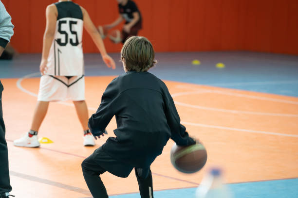 istock Rear view Young boy playing basketball . 1357309178