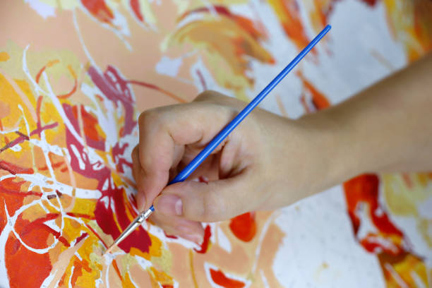 istock Numbers coloring page, female hand with brush on canvas 1357310384