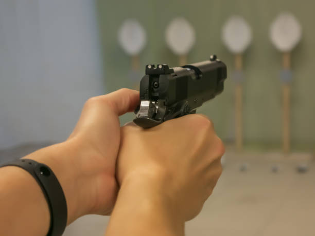 istock A woman with a pistol aiming at a target 1357310468