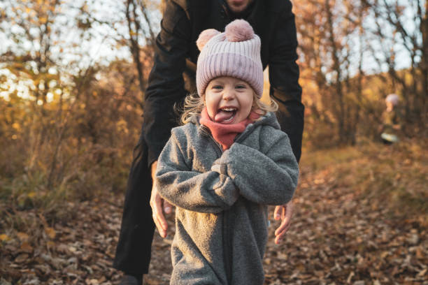 Outdoor Portrait of Happy Toddler Girl Very Happy Toddler Young Girl Sticking out Tongue Having fun Outdoors in Rural Landscape on cold day in Autumn cute baby laughing stock pictures, royalty-free photos & images