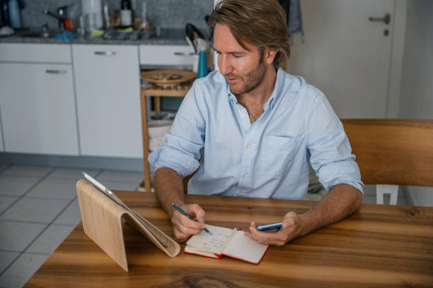 istock Young man online learning at home on digital tablet 1357311761