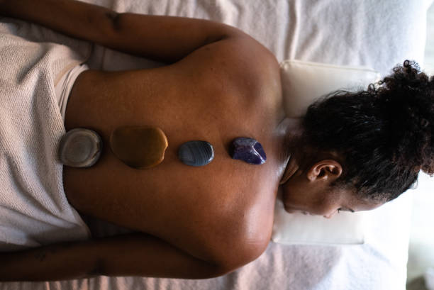 istock Therapist putting hot stones on woman's back at a spa 1357312475
