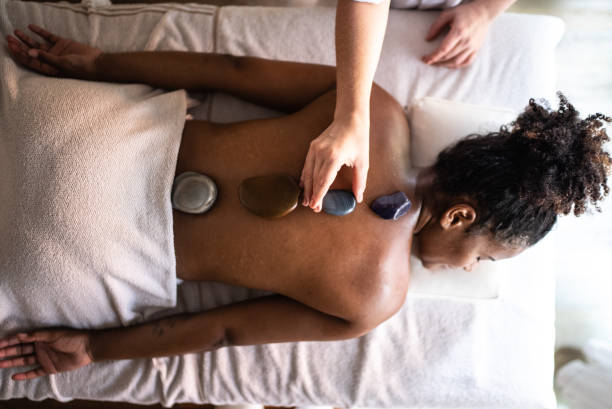 istock Therapist putting hot stones on woman's back at a spa 1357312479