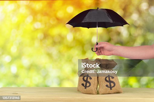 istock A hand protect Group of US dollar bag concept of protection risk development, wealth management and long term monetary investments 1357313145